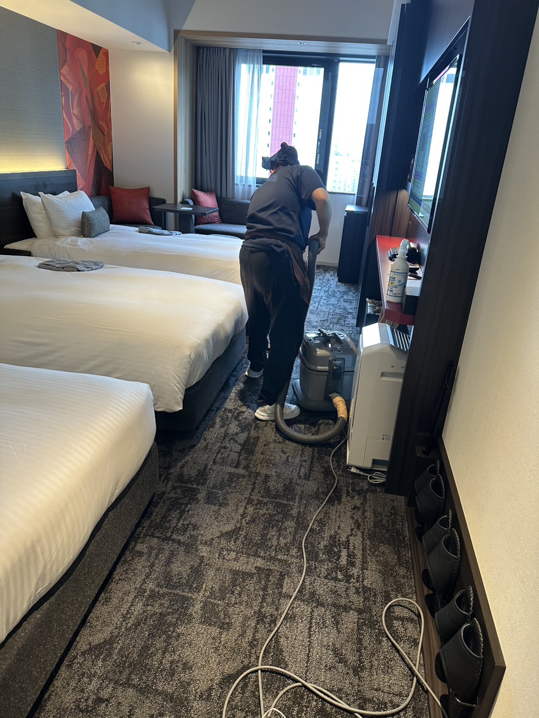 TOYAS staff vacuuming a hotel guest room